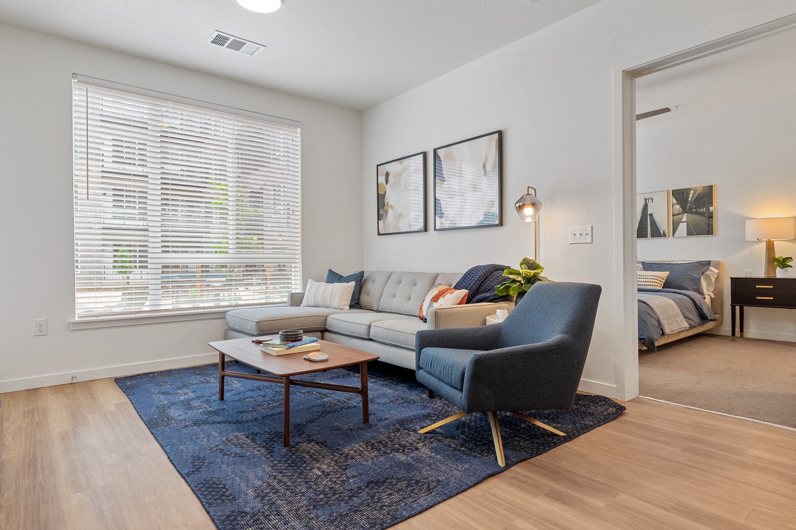 a living room with a couch and a chair in front of a window